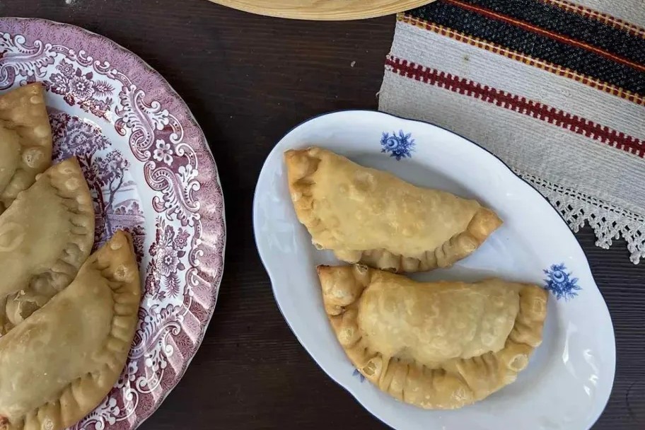 Παραδοσιακά πιτάκια σε πιάτο, σε απλή λήψη που αναδεικνύει το σχήμα και τη γέμιση.