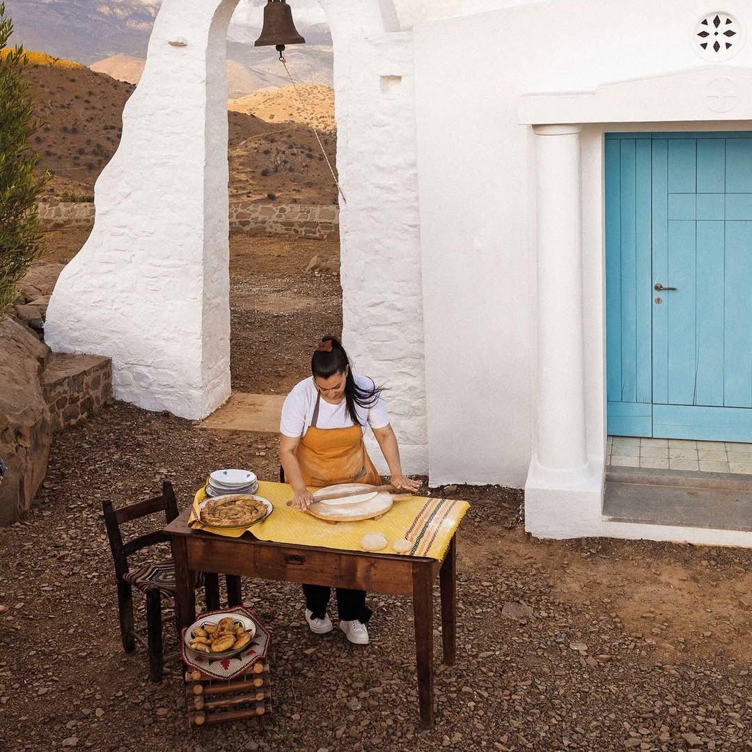 Εξωτερική λήψη του εργαστηρίου σε παραδοσιακό τοπίο με τραπέζι εργασίας και ανθρώπινη παρουσία.