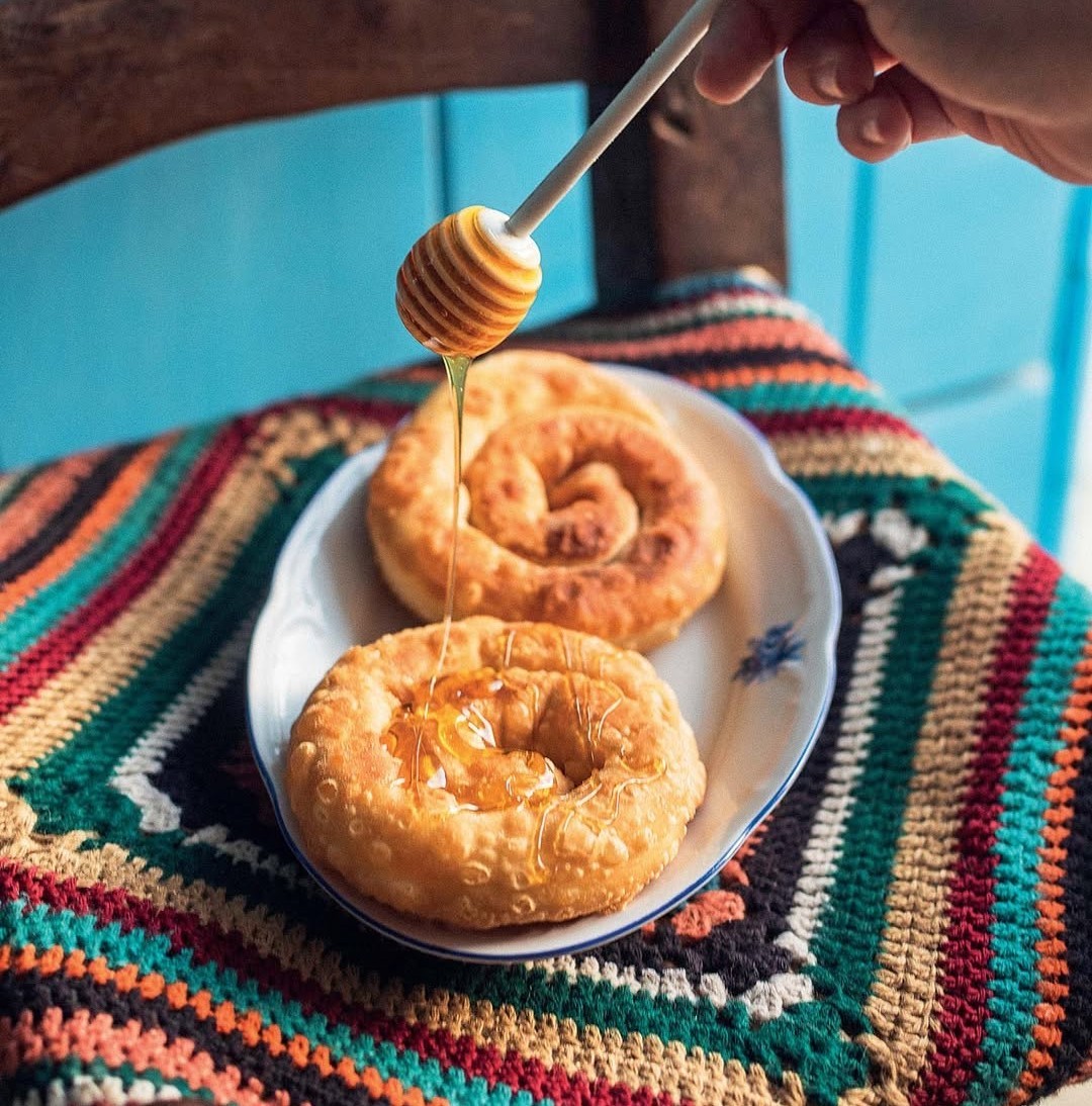 Σερβίρισμα γλυκιάς παραδοσιακής πίτας με μέλι, σε λήψη που αναδεικνύει τη γεύση και την υφή.