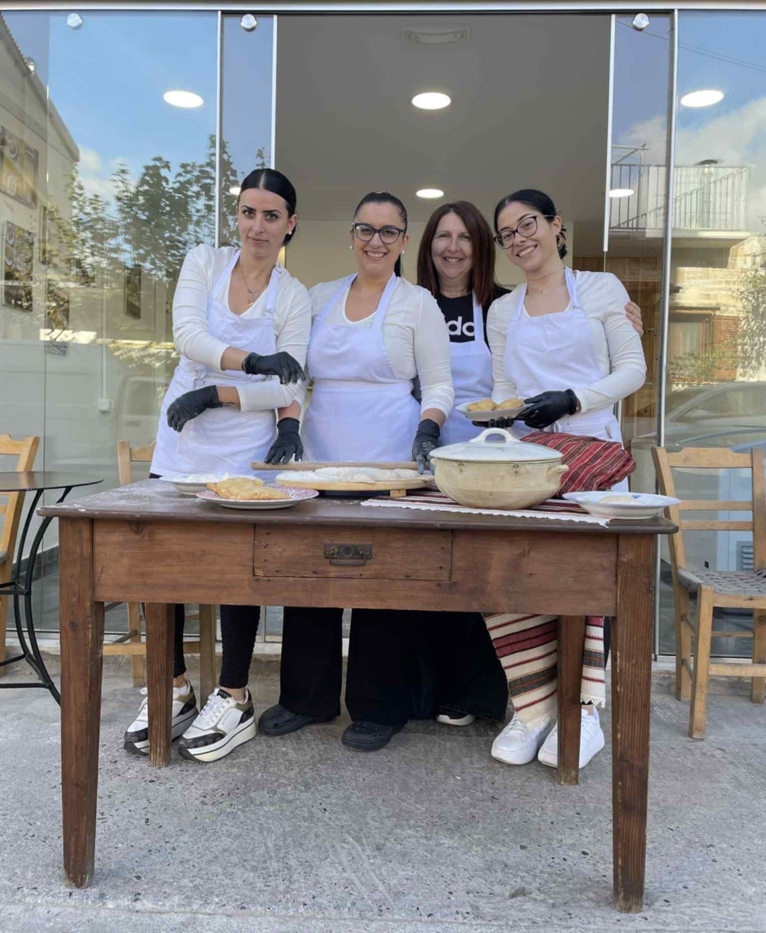 Τα μέλη του εργαστηρίου ποζάρουν με χειροποίητα προϊόντα, ενισχύοντας την ανθρώπινη πλευρά της επιχείρησης.