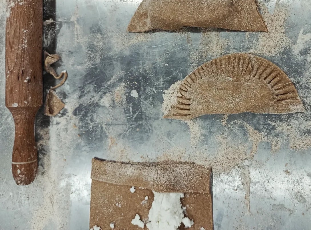 Ρουστίκ σύνθεση με παραδοσιακές πίτες και παλαιωμένη επιφάνεια, σε εικαστική παρουσίαση προϊόντος.