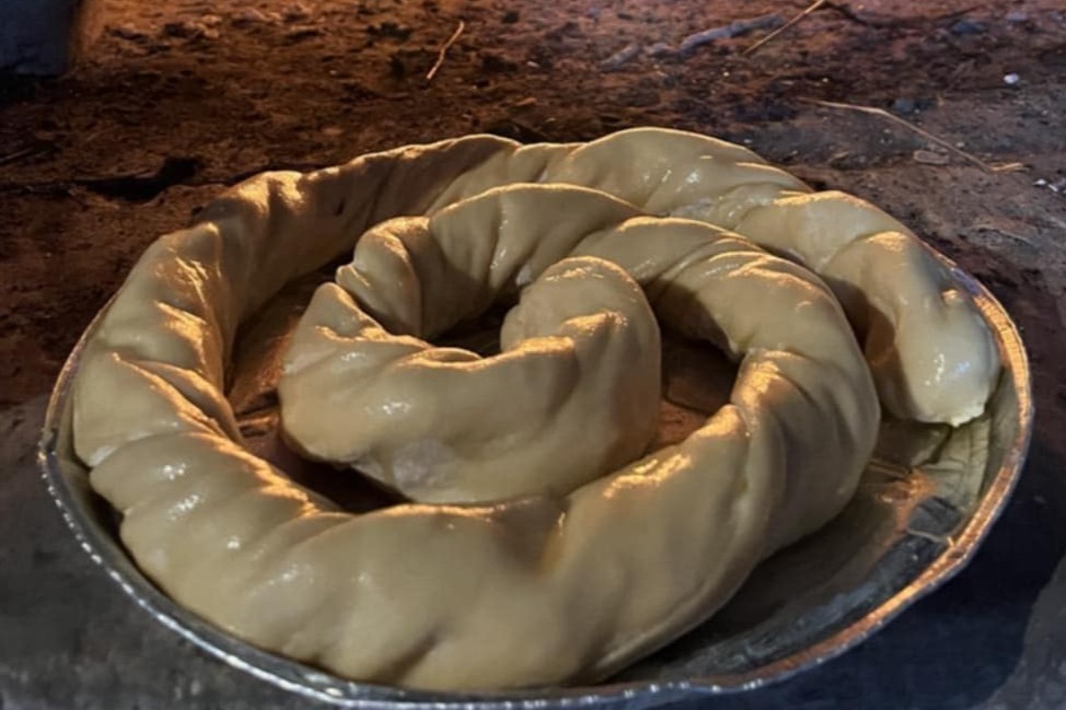 Παραδοσιακή στρογγυλή πίτα σε πιάτο, σε κοντινή λήψη που αναδεικνύει το τελικό αποτέλεσμα.