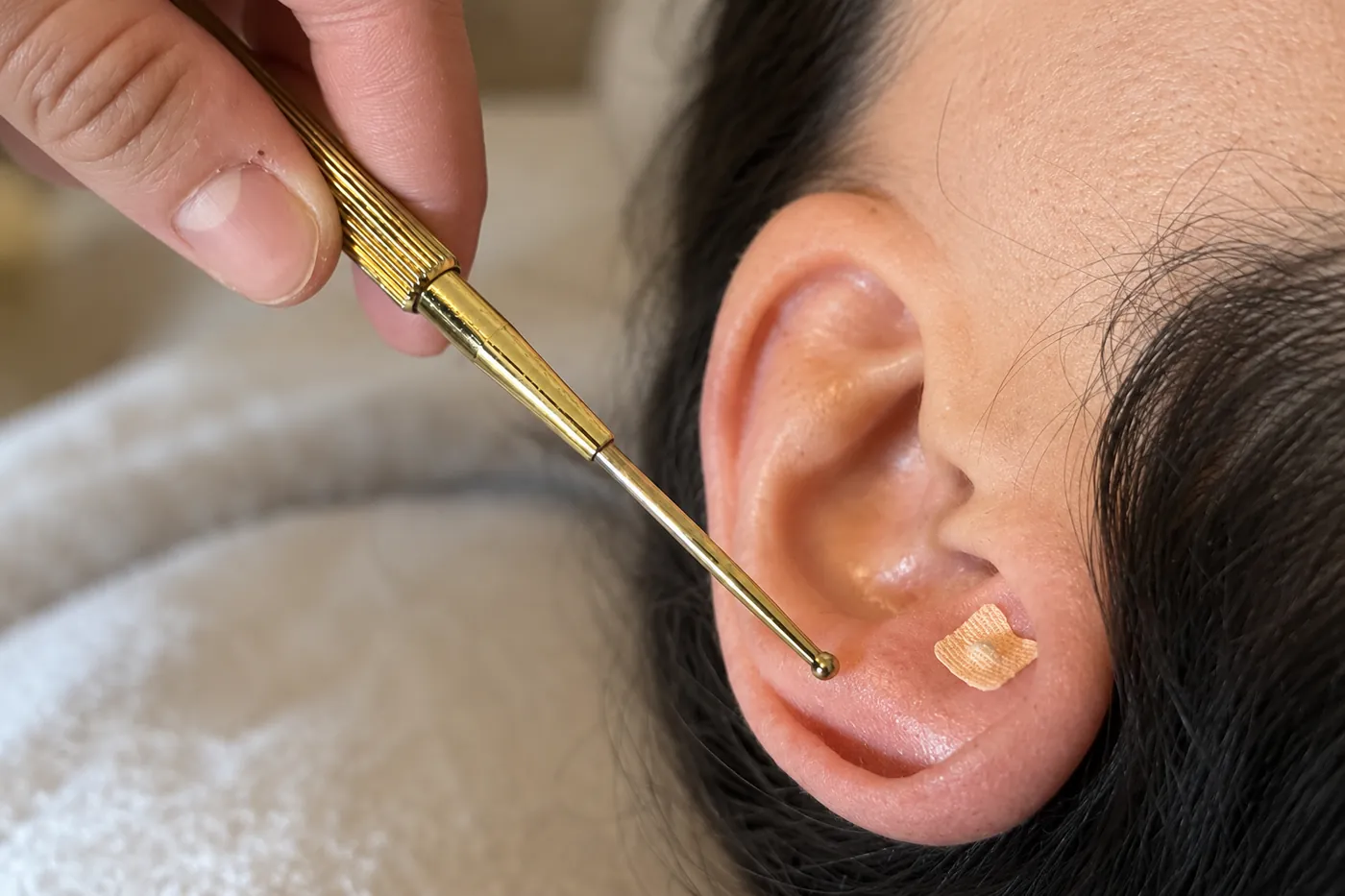 Τοποθέτηση Ear Seed στο αυτί με χρυσό εργαλείο